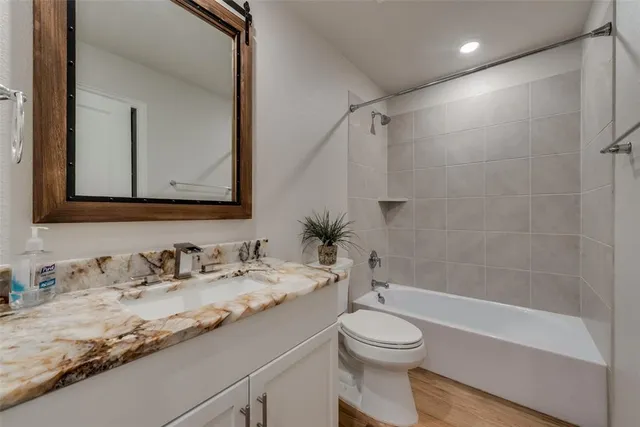 a bathroom with a granite countertop sink toilet and shower