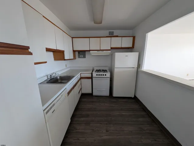 a kitchen with white cabinets and white appliances