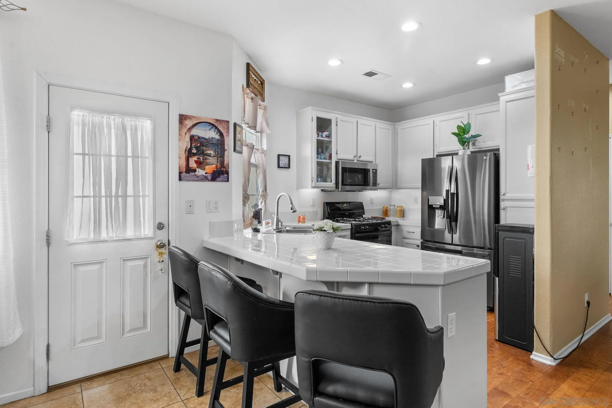 1924 Geyserville Street Chula Vista, CA 91913 - Photo 11 of 37 a kitchen with stainless steel appliances a table chairs and refrigerator