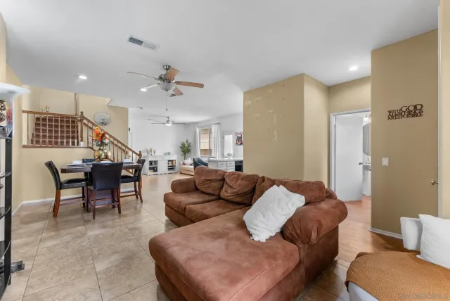 a living room with furniture kitchen view and a chandelier