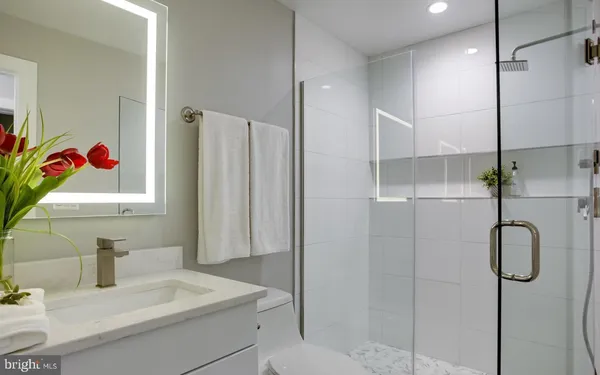 a bathroom with a sink vanity mirror and shower