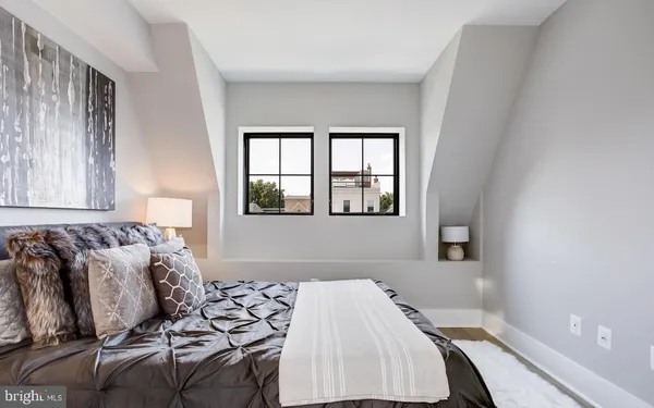 a bed sitting in a bedroom next to a window