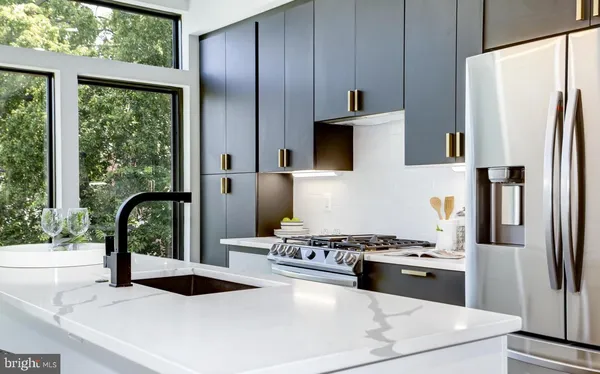 a kitchen with stainless steel appliances granite countertop a sink stove and refrigerator