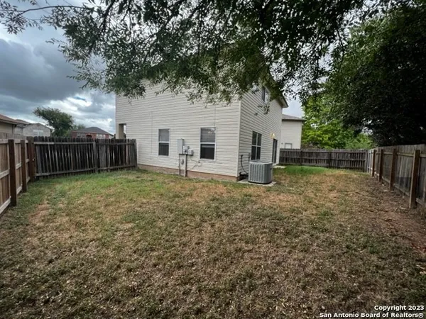 a view of a house with backyard and tree
