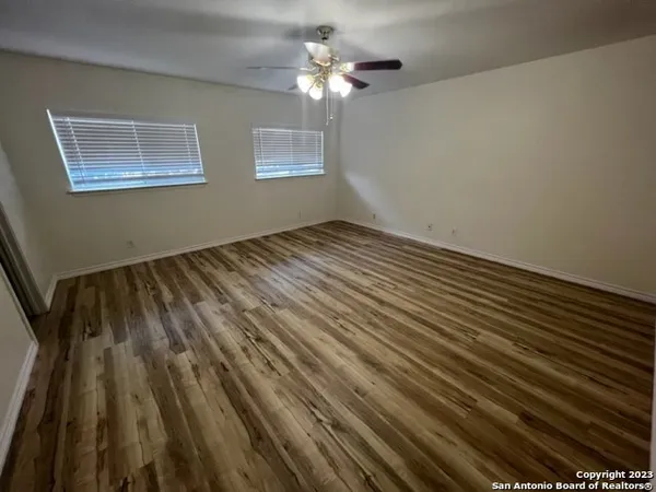 a view of empty room with wooden floor