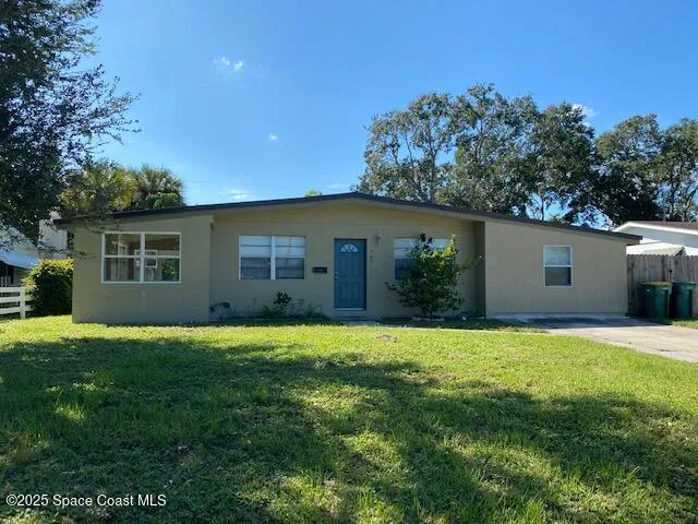 a backyard of a house with large trees and plants