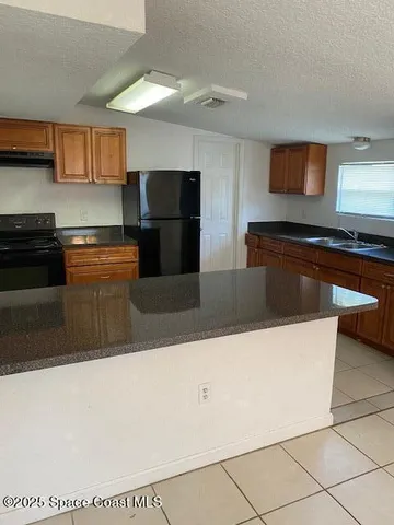 a kitchen with stainless steel appliances granite countertop a sink and a refrigerator
