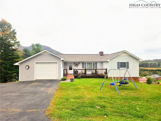 a view of a house with a yard and sitting area