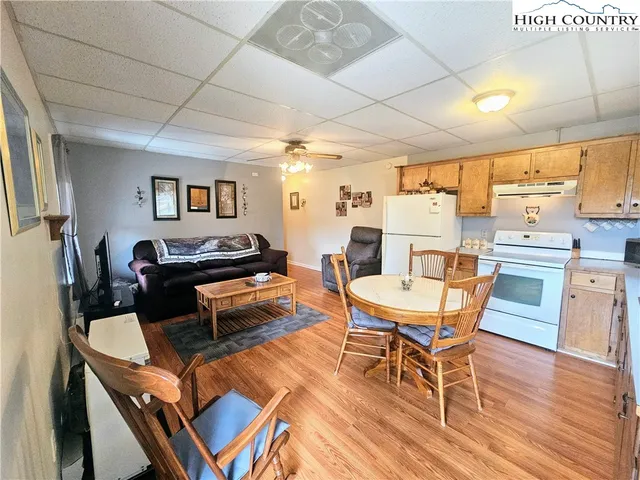 a living room with furniture a wooden floor and next to a window