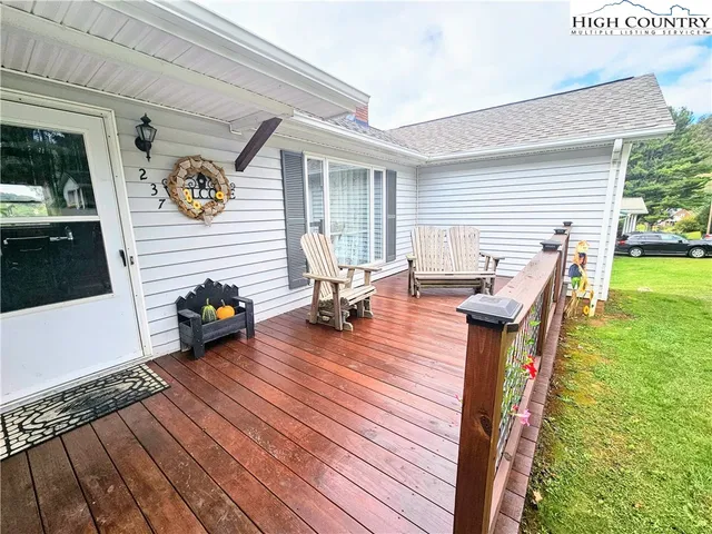 a backyard of a house with wooden floor and outdoor seating