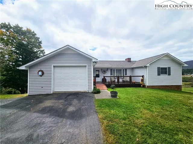 a view of a house with a yard and sitting area