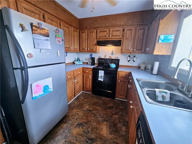 a kitchen with stainless steel appliances granite countertop a refrigerator stove a sink and dishwasher