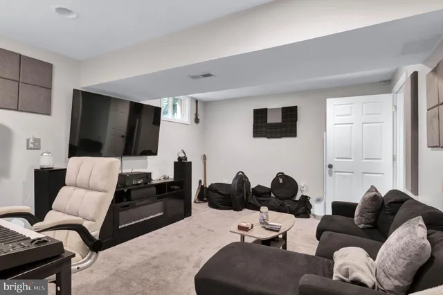 a living room with a bed and a large mirror on dresser