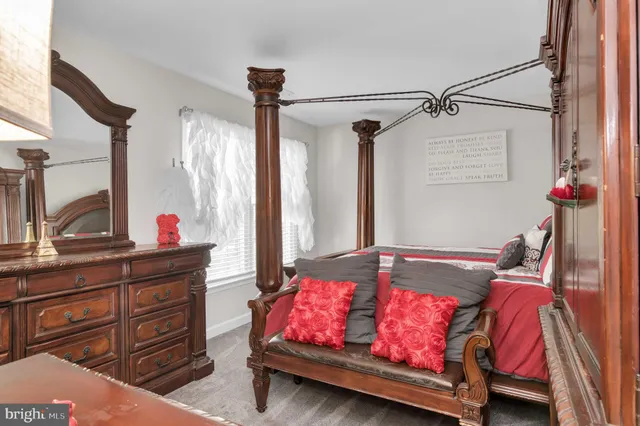 a bedroom with a bed a flat screen tv and a fireplace