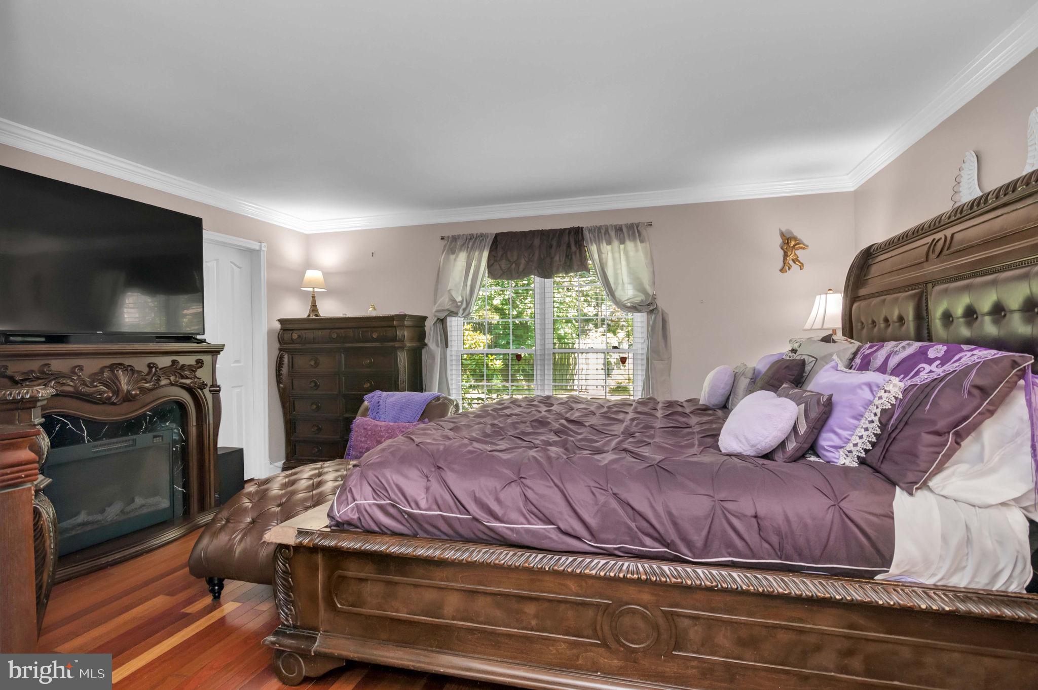 10404 Amherst Circle Fredericksburg, VA 22408 - Photo 48 of 74 a bedroom with a bed a flat screen tv and a fireplace