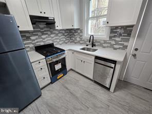 2437 West Toronto Street Philadelphia, PA 19132 - Photo 7 of 14 a kitchen with a sink stove and cabinets