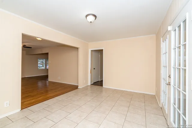 a view of an empty room with window and stairs
