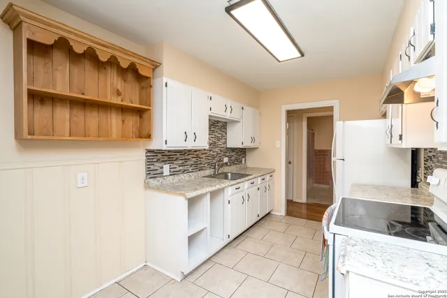 a kitchen with stainless steel appliances granite countertop a sink stove and cabinets