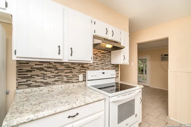 a kitchen with granite countertop a sink and a stove