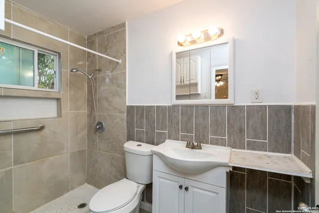 a bathroom with a sink a toilet and shower