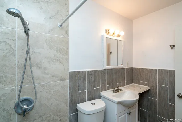 a bathroom with a sink toilet and shower