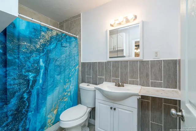 a bathroom with a sink a toilet and mirror