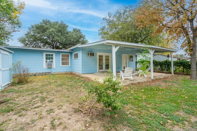 a view of a house with backyard and sitting area