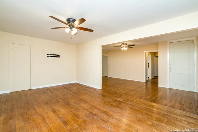 a view of empty room with wooden floor