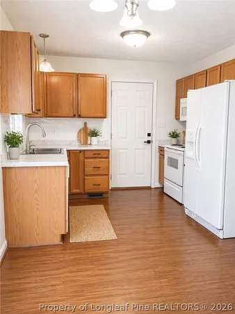 a kitchen with granite countertop a refrigerator and a sink
