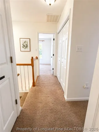 a view of a hallway with wooden floor and entryway