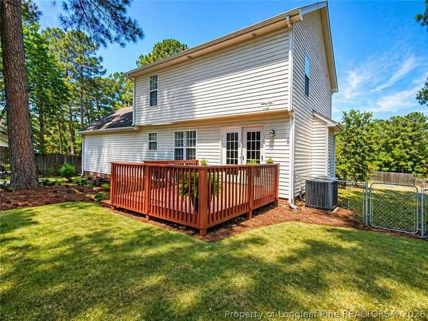 a view of a house with a yard and deck area with a garden