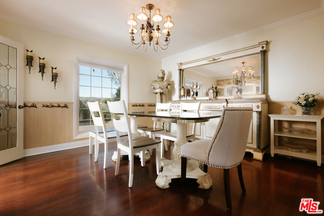 5741 Rolling Road Woodland Hills, CA 91367 - Photo 17 of 37 a dining room with furniture a chandelier and wooden floor