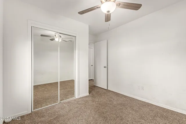 an empty room with chandelier fan