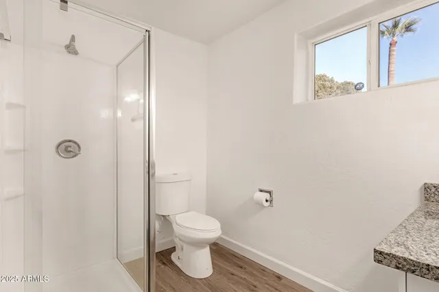 a bathroom with a toilet and a shower