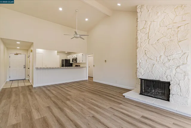 a view of empty room with wooden floor and fireplace