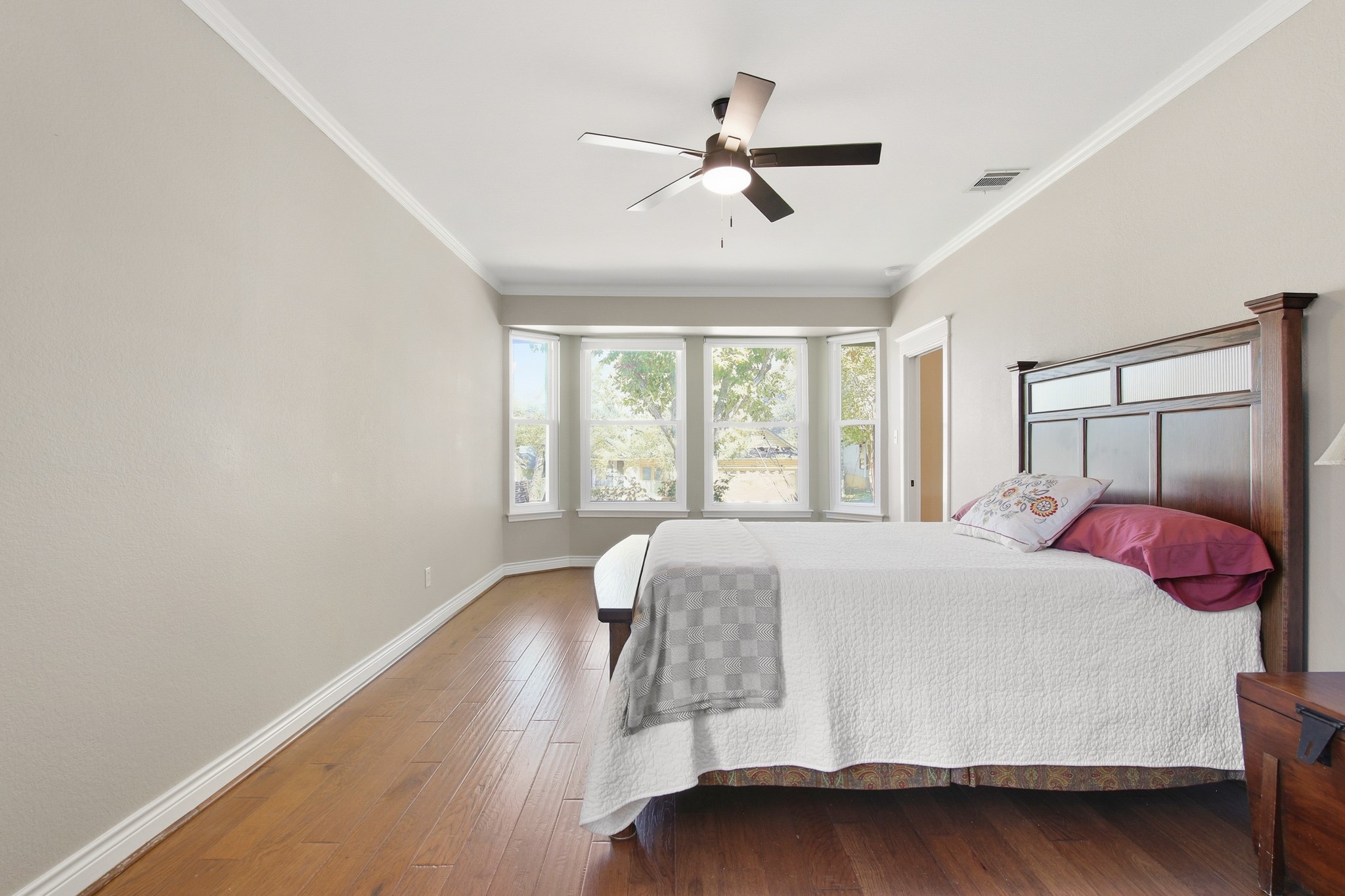 1711 Prairie Hen Cove Austin, TX 78758 - Photo 11 of 18 Bedroom with ornamental molding, hardwood / wood-style flooring, and a ceiling fan