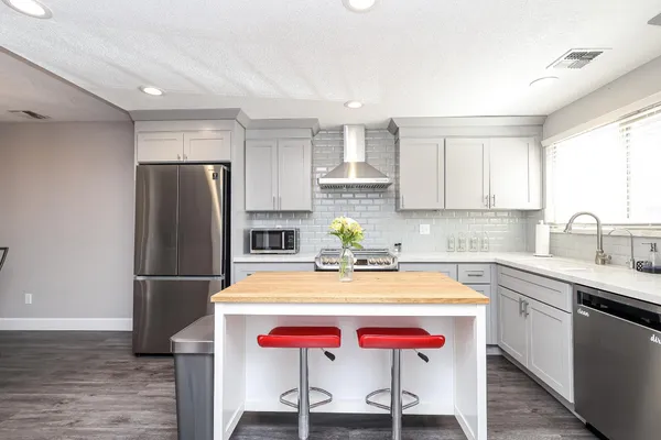 a kitchen with a sink a stove a refrigerator and cabinets