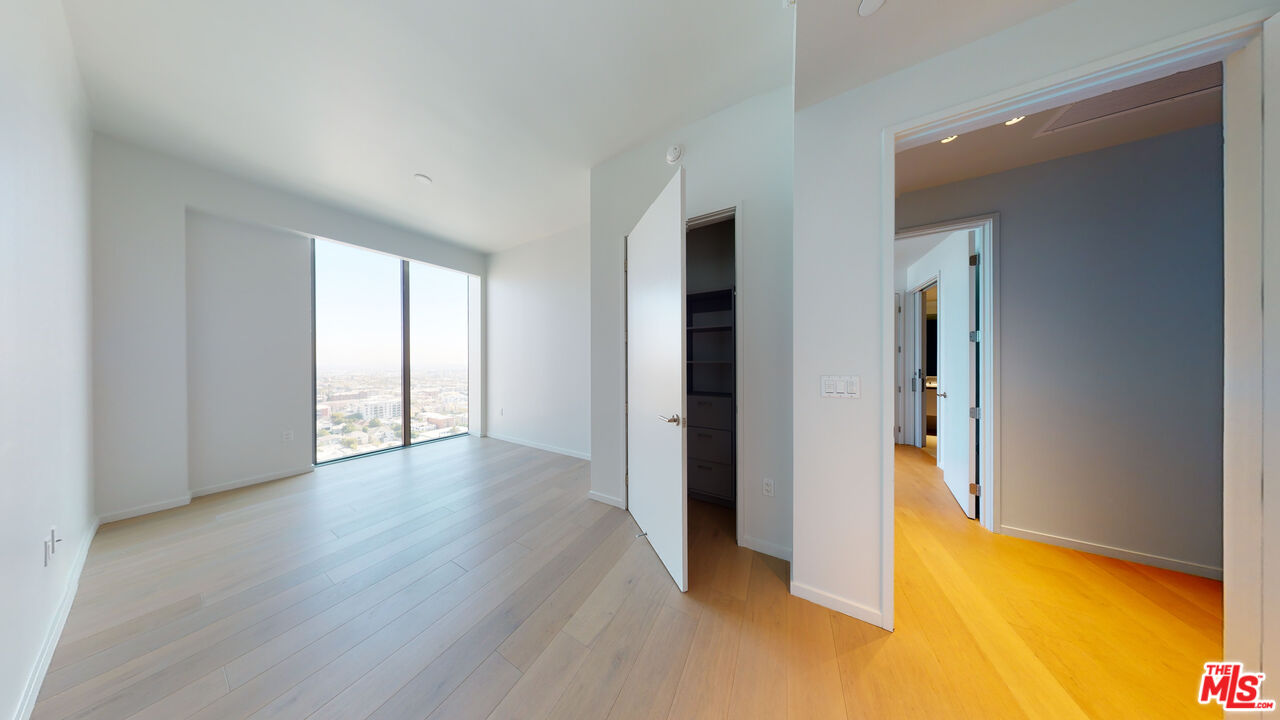 2801 Sunset Place, Unit PH15 Los Angeles, CA 90005 - Photo 16 of 23 a view of an empty room with a window and wooden floor