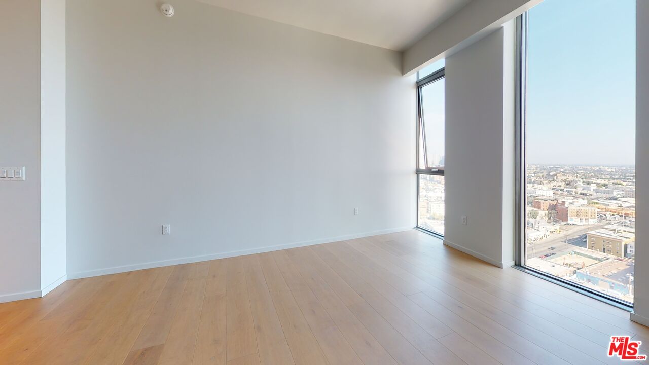 2801 Sunset Place, Unit PH15 Los Angeles, CA 90005 - Photo 22 of 23 an empty room with wooden floor and windows