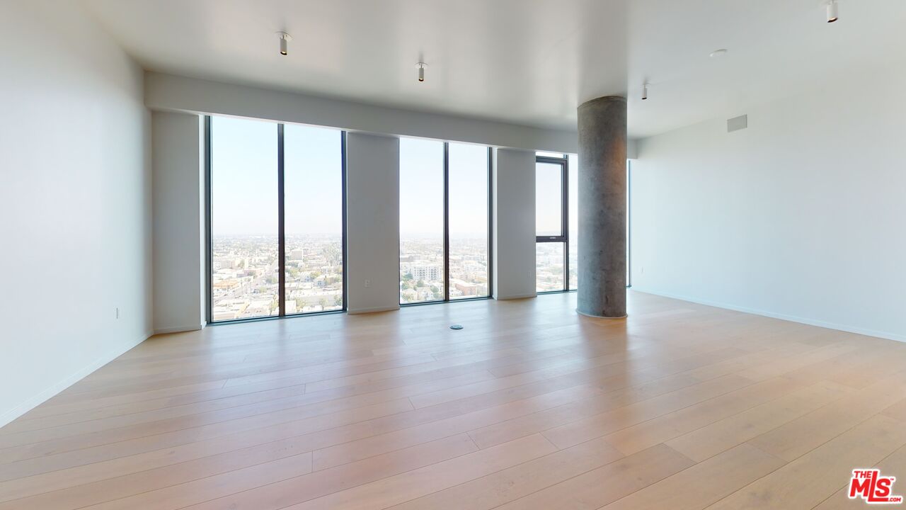 2801 Sunset Place, Unit PH15 Los Angeles, CA 90005 - Photo 9 of 23 a view of an empty room with wooden floor and a window