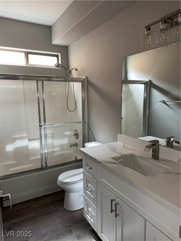 8993 Dorrell Lane Las Vegas, NV 89149 - Photo 14 of 15 Bathroom featuring vanity, enclosed tub / shower combo, and wood finished floors