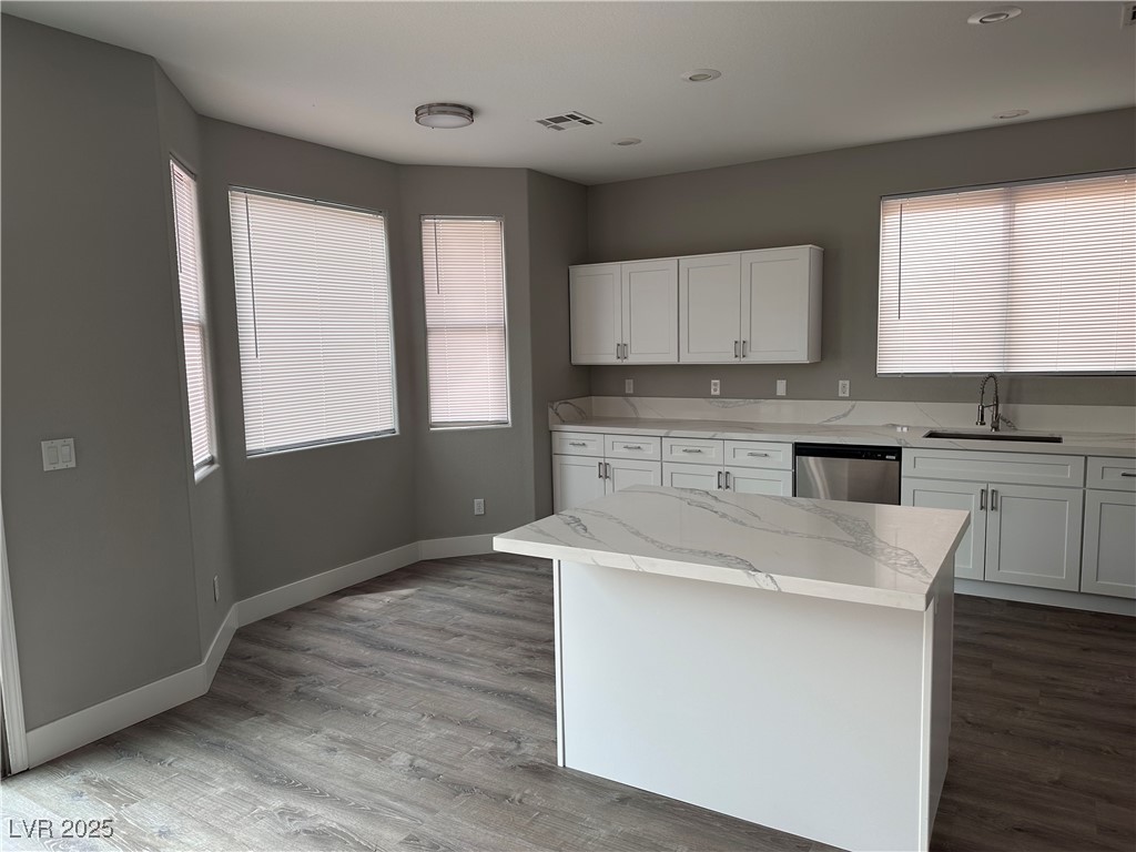 8993 Dorrell Lane Las Vegas, NV 89149 - Photo 3 of 15 Kitchen with dishwasher, light wood-style flooring, and white cabinetry