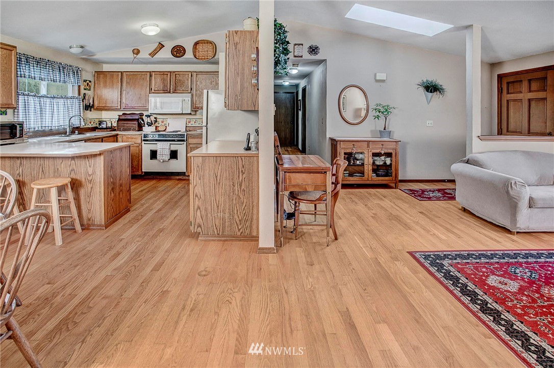 23431 12th Place West Bothell, WA 98021 - Photo 7 of 26 a living room with stainless steel appliances granite countertop furniture wooden floor and a view of kitchen