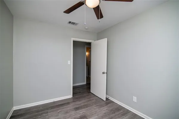 an empty room with closet and windows