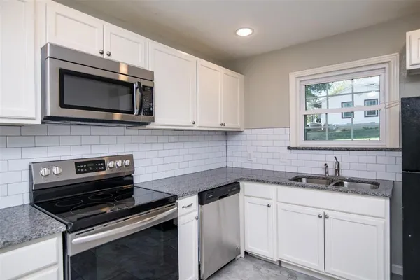 a kitchen with stainless steel appliances a stove sink microwave and cabinets
