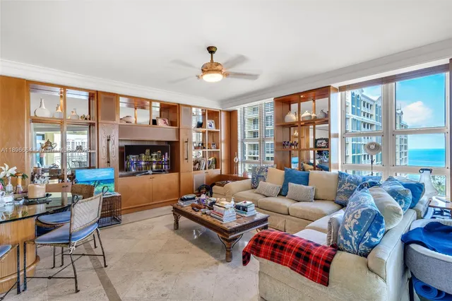 a large white kitchen with lots of counter space and chandelier