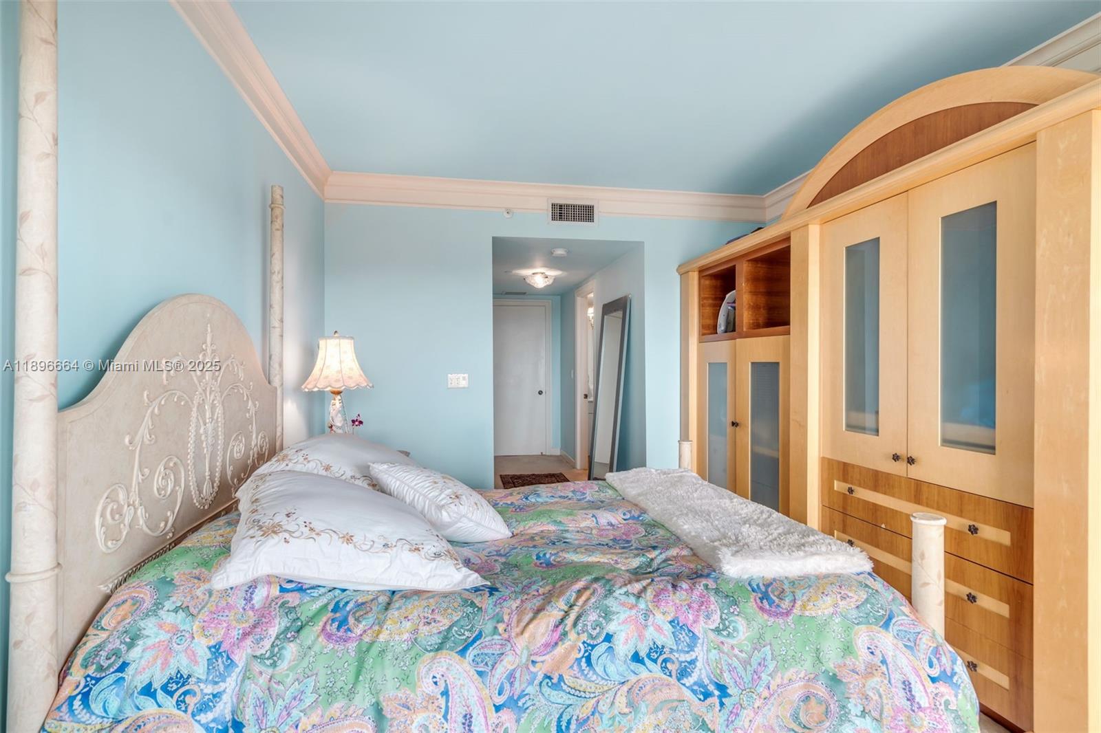 445 Grand Bay Drive, Unit 1001 Key Biscayne, FL 33149 - Photo 40 of 57 a bedroom with a bed and a chandelier