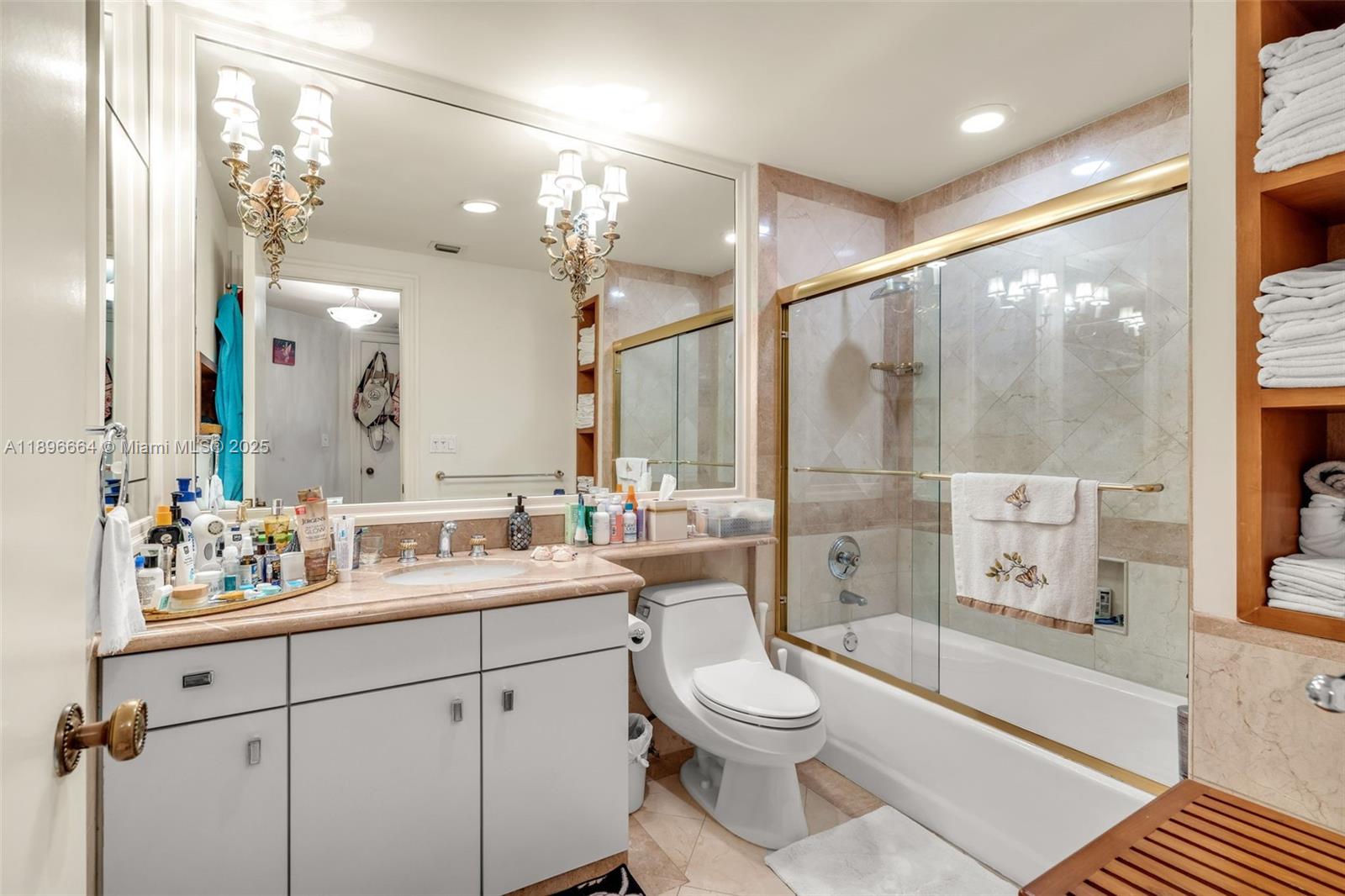 445 Grand Bay Drive, Unit 1001 Key Biscayne, FL 33149 - Photo 44 of 57 a bathroom with a double vanity sink toilet mirror and shower