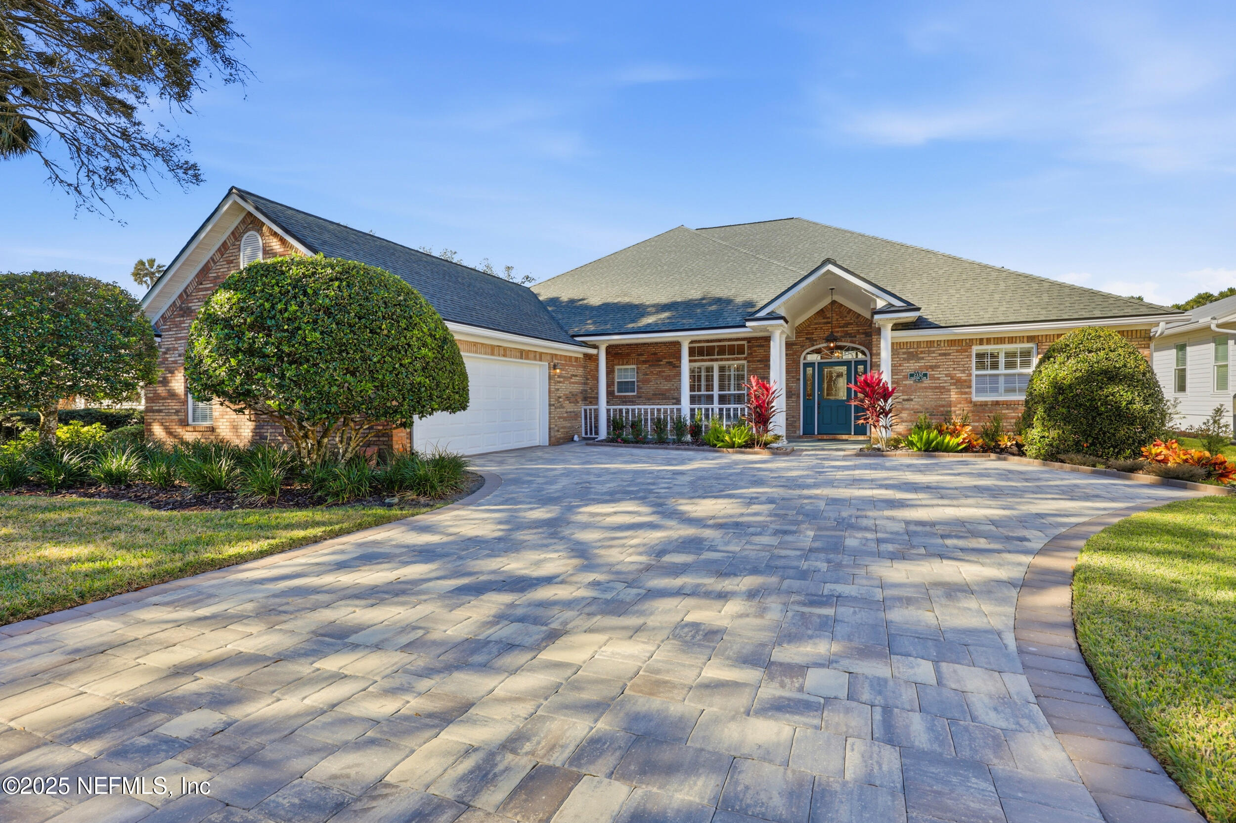 a front view of a house with a yard and potted plants