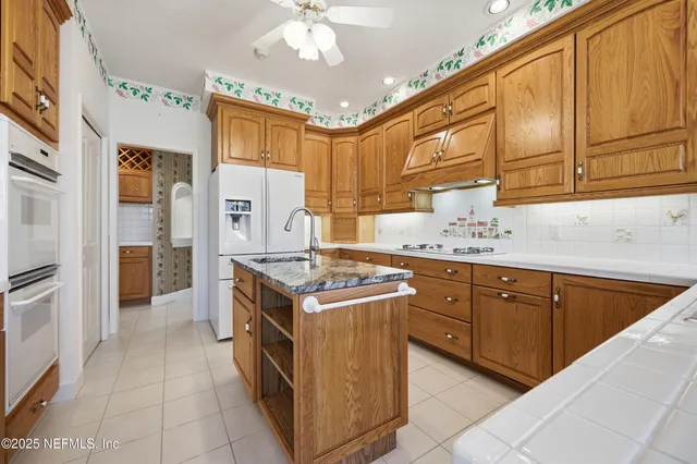 a kitchen with granite countertop a sink stove and refrigerator